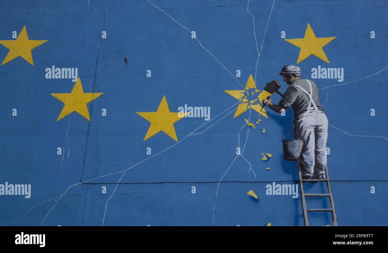(190223) -- DOVER, 23. Februar 2019 (Xinhua) -- Foto aufgenommen am 22. Februar 2019 zeigt ein gemaltes Wandgemälde des britischen Graffiti-Künstlers Banksy, das einen Arbeiter zeigt, der an einem der Sterne auf einer EU-Flagge in Dover, Großbritannien, abplatzt. (Xinhua/Han Yan) BRITAIN-DOVER-BANKSY-MURAL PUBLICATIONxNOTxINxCHN Stockfoto