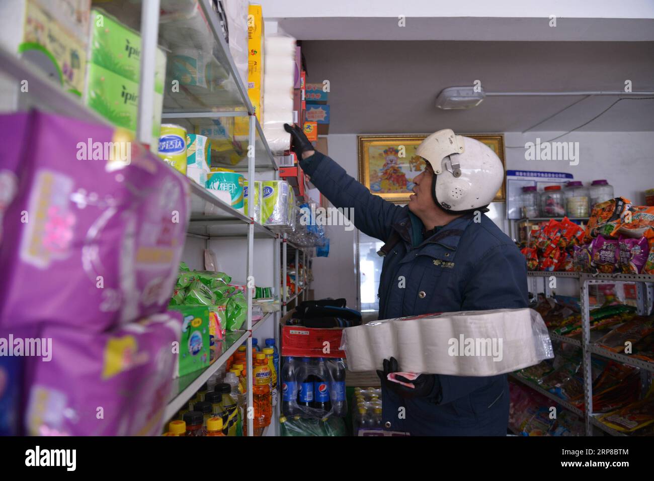 (190226) -- CHANGCHUN, 26. Februar 2019 (Xinhua) -- Postmann Jin Renzhe holt Lebensmittel für ältere Menschen in der Chunhua-Gemeinde der Stadt Huichun, nordöstliche Provinz Jilin, 19. Februar 2019 ab. Jin Renzhe ist seit 30 Jahren als Postbote in der Gemeinde Chunhua tätig, wo der Postdienst aufgrund steiler Bergpfade und lose verstreuter Dörfer unzureichend ist. Trotzdem gelingt es Jin, am selben Tag, an dem die Post in der Stadt ankommt, Mails an die Dorfbewohner zu liefern. Da viele junge Menschen außerhalb der Stadt arbeiten, verbindet Jin sie und ihre Eltern durch die Lieferung von Paketen. Leben mit Augenkrankheiten und Kunst Stockfoto