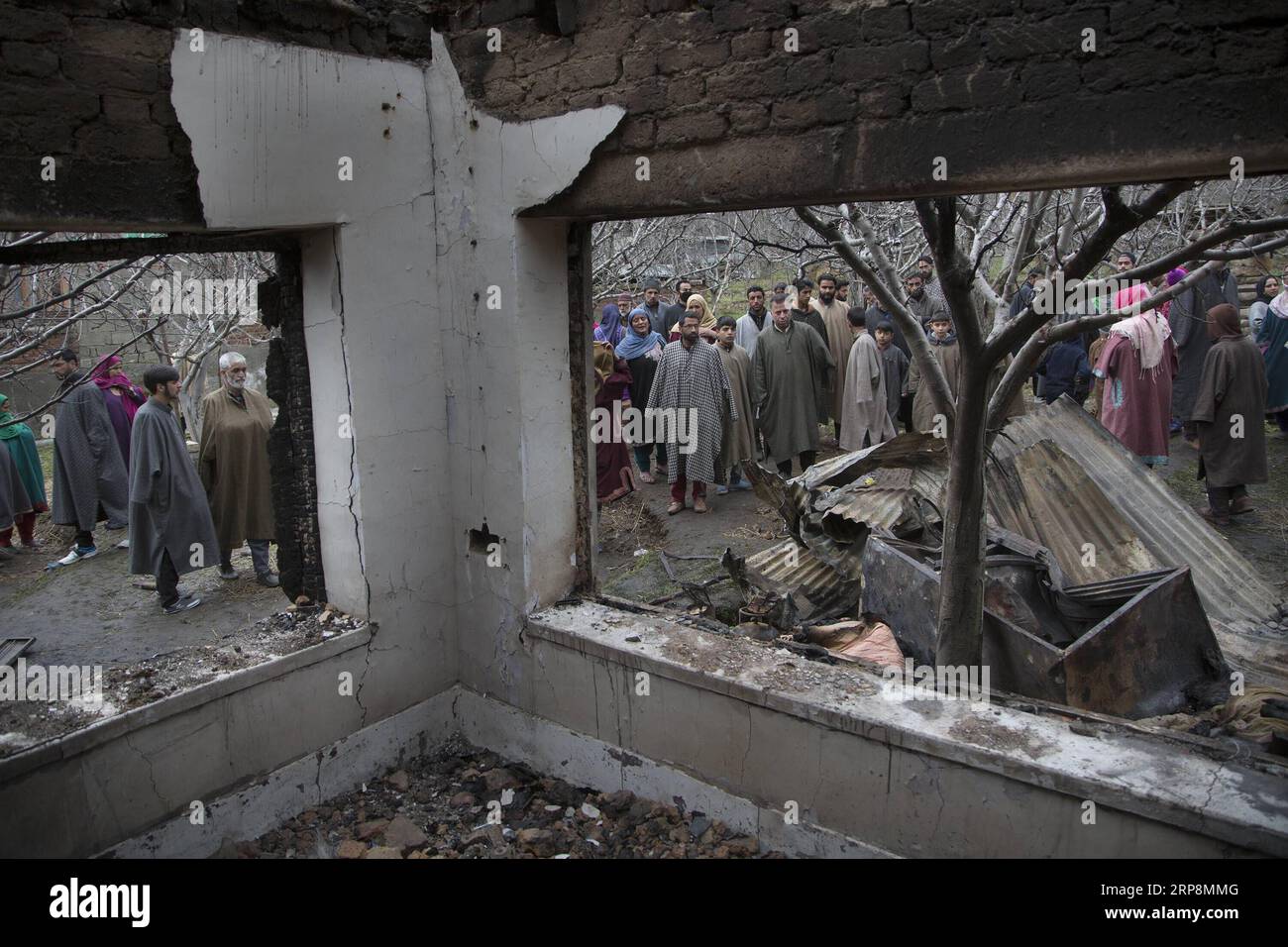 (190311) -- SRINAGAR, 11. März 2019 -- Menschen versammeln sich in der Nähe eines Hauses, das während einer Schießerei im Bezirk Tral of Pulwama, etwa 40 km südlich von Srinagar, der Sommerhauptstadt des von Indien kontrollierten Kaschmirs, am 11. März 2019 zerstört wurde. Indische Sicherheitskräfte behaupteten am Montag, den Drahtzieher hinter dem Pulwama-Angriff am 14. Februar getötet zu haben, bei dem mindestens 40 Sicherheitspersonal der Central Reserve Police Force (CRPF) getötet wurden. Ein hochrangiger indischer Offizier bestätigte dies, dass der als Mudasir Khan identifizierte Mastermind der extremistischen Gruppe Jaish-e-Mohammd (Jem) zu den drei Milita gehörte Stockfoto