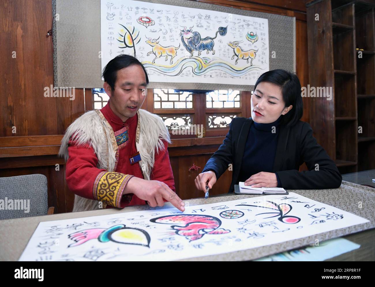 (190313) -- PEKING, 13. März 2019 -- Fan Yongzhen (R), ein Abgeordneter des 13. Nationalen Volkskongresses (NPC), führt eine Forschung über die Dongba-Bildsprache im Dorf Yushuizhai des autonomen Komitats Yulong Naxi in Lijiang, Provinz Yunnan im Südwesten Chinas, 13. Februar 2019 durch. ) Xinhua-Schlagzeilen: Für das Volk sprechen die Volksvertreter auf zwei Sitzungen YangxZongyou PUBLICATIONxNOTxINxCHN Stockfoto