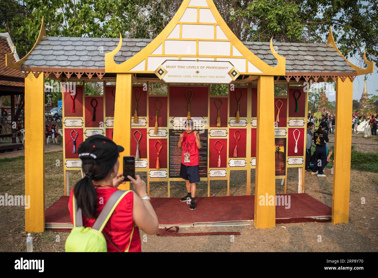 (190318) -- AYUTTHAYA, 18. März 2019 (Xinhua) -- Ein Mann posiert für ein Foto mit Mongkons während der 15. World Wai Kru Muay Thai Zeremonie in Ayutthaya, Thailand, 17. März 2019. Die Zeremonie, die jährlich im Ayutthaya Historical Park stattfindet, bietet Hunderten von Muay Thai-Praktizierenden aus der ganzen Welt die Möglichkeit, ihren Meistern in der altehrwürdigen Tradition, der sogenannten Wai Kru-Zeremonie, ihren Dank auszusprechen. und um die alte Kampfkunst Muay Thai zu feiern. (Xinhua/Zhang Keren) (SP)THAILAND-AYUTTHAYA-MUAY THAI-CEREMONY PUBLICATIONxNOTxINxCHN Stockfoto