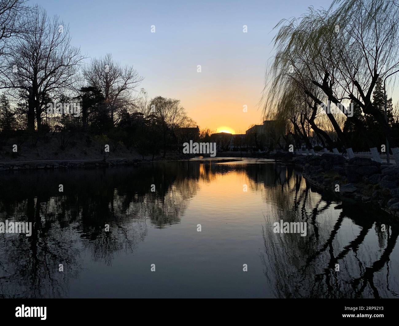 (190321) -- PEKING, 21. März 2019 -- Foto aufgenommen am 21. März 2019 mit Handy zeigt den Sonnenuntergang an der Tsinghua Universität im Haidian Bezirk von Peking, Hauptstadt von China. ) (BeijingCandid) CHINA-BEIJING-SPRING (CN) CuixBowen PUBLICATIONxNOTxINxCHN Stockfoto
