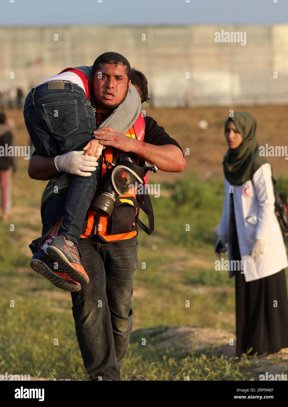 (190322) -- GAZA, 22. März 2019 -- Ein Palästinenser trägt einen Verwundeten bei Zusammenstößen mit israelischen Truppen an der Grenze zwischen Gaza und Israel, östlich von Gaza-Stadt, 22. März 2019. Mindestens zwei Palästinenser wurden am Freitagnachmittag während der wöchentlichen Proteste gegen Israel, besser bekannt als der große Rückkehrmarsch, von israelischem Schuss erschossen. MIDEAST-GAZA-KONFLIKTE YasserxQudih PUBLICATIONxNOTxINxCHN Stockfoto