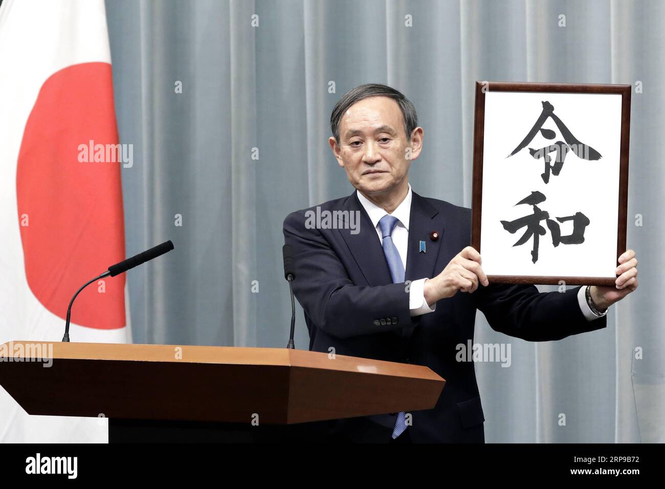 (190401) -- TOKIO, 1. April 2019 (Xinhua) -- Japans Kabinettssekretär Yoshihide Suga hält ein gerahmtes Bild von Reiwa, dem Namen der neuen Ära Japans, während einer Pressekonferenz in Tokio, Japan, am 1. April 2019. Die japanische Regierung gab am Montag bekannt, dass Reiwa der Name der neuen Ära Japans sein wird, die am 1. Mai beginnen wird, als Kronprinz Naruhito den Chrysanthemen-Thron als Nachfolger seines Vaters Kaiser Akihito bestiegen wird. Der Name der neuen Ära, bestehend aus zwei chinesischen Schriftzeichen, die grob übersetzt für geordnet oder verheißungsvoll und Frieden oder Harmonie stehen, leitet sich von man yoshu ab, der ältesten Anthologie o Stockfoto