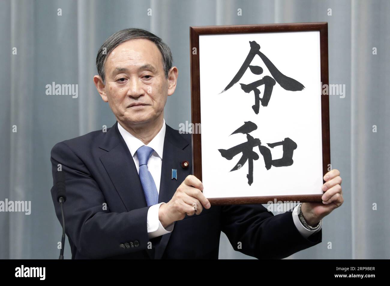 (190401) -- TOKIO, 1. April 2019 (Xinhua) -- Japans Kabinettssekretär Yoshihide Suga hält ein gerahmtes Bild von Reiwa, dem Namen der neuen Ära Japans, während einer Pressekonferenz in Tokio, Japan, am 1. April 2019. Die japanische Regierung gab am Montag bekannt, dass Reiwa der Name der neuen Ära Japans sein wird, die am 1. Mai beginnen wird, als Kronprinz Naruhito den Chrysanthemen-Thron als Nachfolger seines Vaters Kaiser Akihito bestiegen wird. Der Name der neuen Ära, bestehend aus zwei chinesischen Schriftzeichen, die grob übersetzt für geordnet oder verheißungsvoll und Frieden oder Harmonie stehen, leitet sich von man yoshu ab, der ältesten Anthologie o Stockfoto