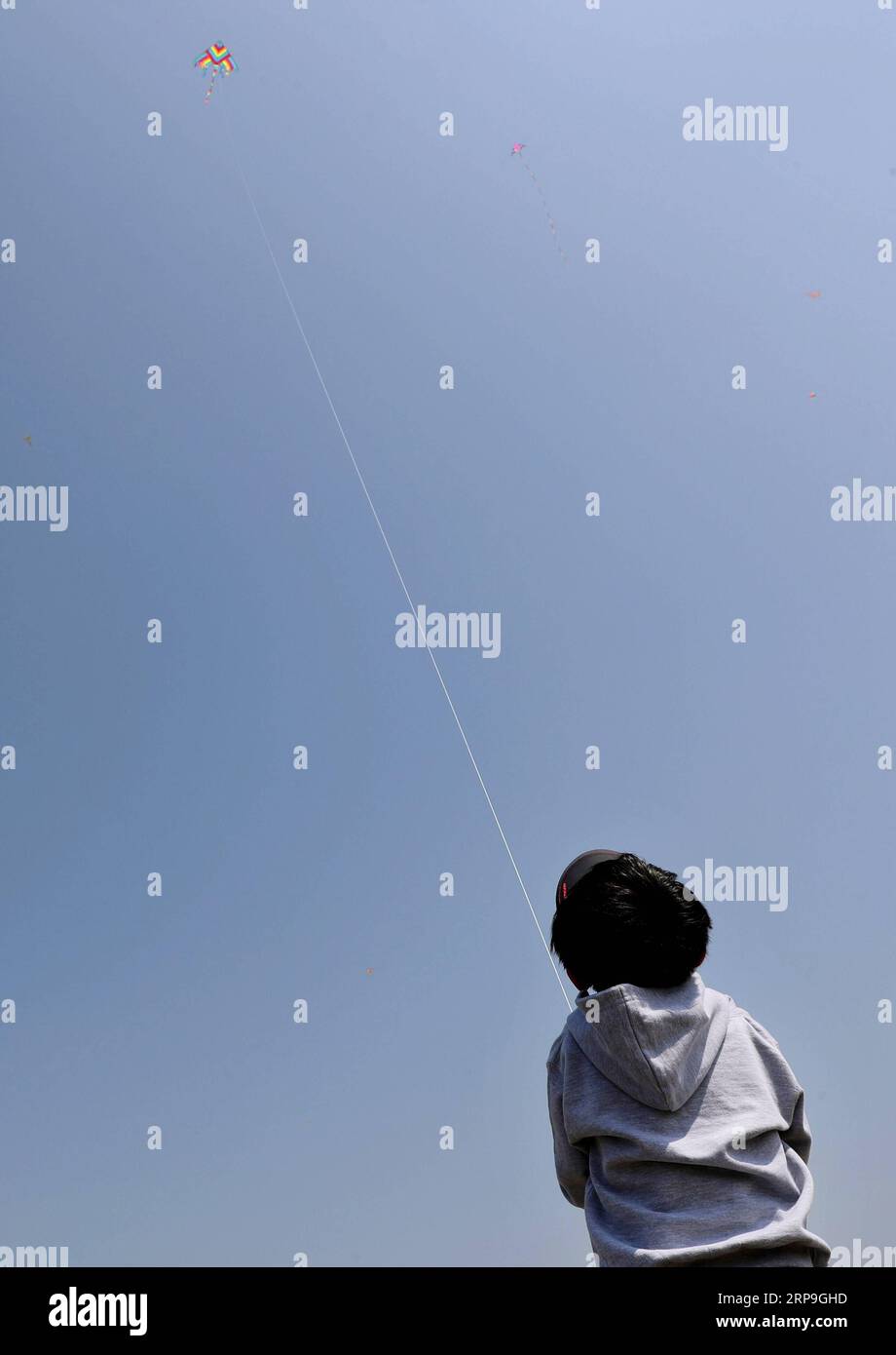 (190406) -- SHANGHAI, 6. April 2019 (Xinhua) -- Ein Kind fliegt einen Drachen am zweiten Tag eines dreitägigen Qingming Festival Nationalfeiertags in der Lingang New City im ostchinesischen Shanghai, 6. April 2019. (Xinhua/Liu Ying) CHINA-QINGMING-HOLIDAY-FREIZEIT-TOURISMUS (CN) PUBLICATIONxNOTxINxCHN Stockfoto