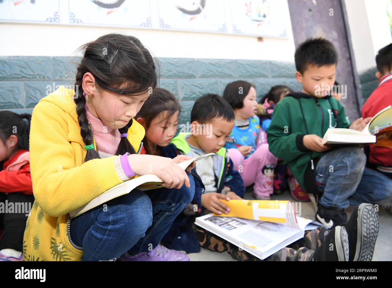 (190418) -- YUEXI, 18. April 2019 (Xinhua) -- Schüler der Baisha Primary School lesen Bücher, die ihnen in der Stadt Yexi, Provinz Yuexi in der ostchinesischen Provinz Anhui, am 17. April 2019 gespendet wurden. Mehr als 600 Bücher wurden an Schüler der Baisha Primary School gespendet und hier wurde eine Busbibliothek eingerichtet, die Schülern in den Bergregionen die Möglichkeit bietet, Bücher zu lesen. (Xinhua/Zhang Duan) CHINA-ANHUI-YUEXI-PRIMARY SCHOOL-BOOK DONATION (CN) PUBLICATIONxNOTxINxCHN Stockfoto