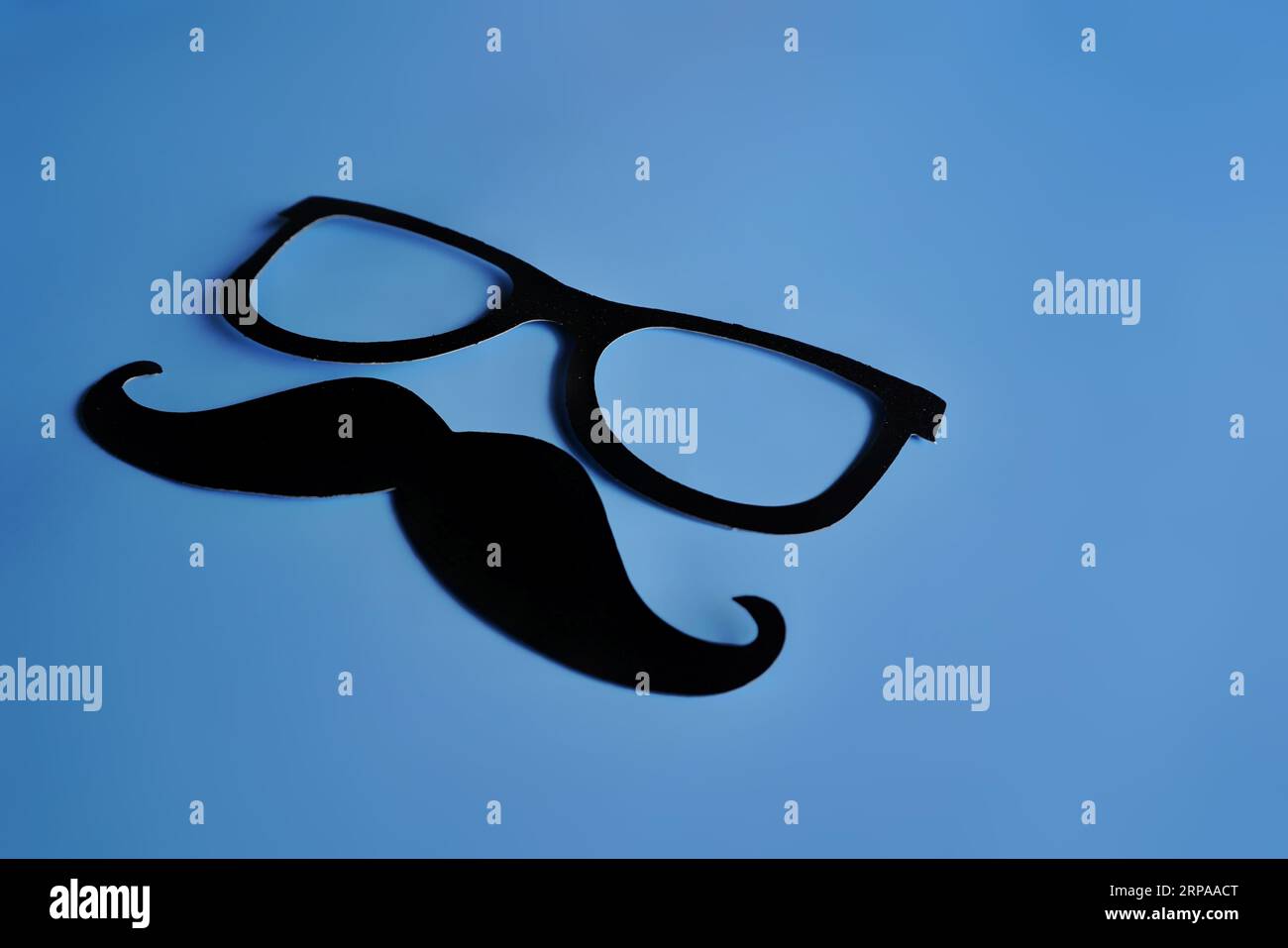 Schnurrbart und Brille auf blauem Hintergrund mit Kopierraum. Movember, Gesundheitskonzept für Männer Stockfoto