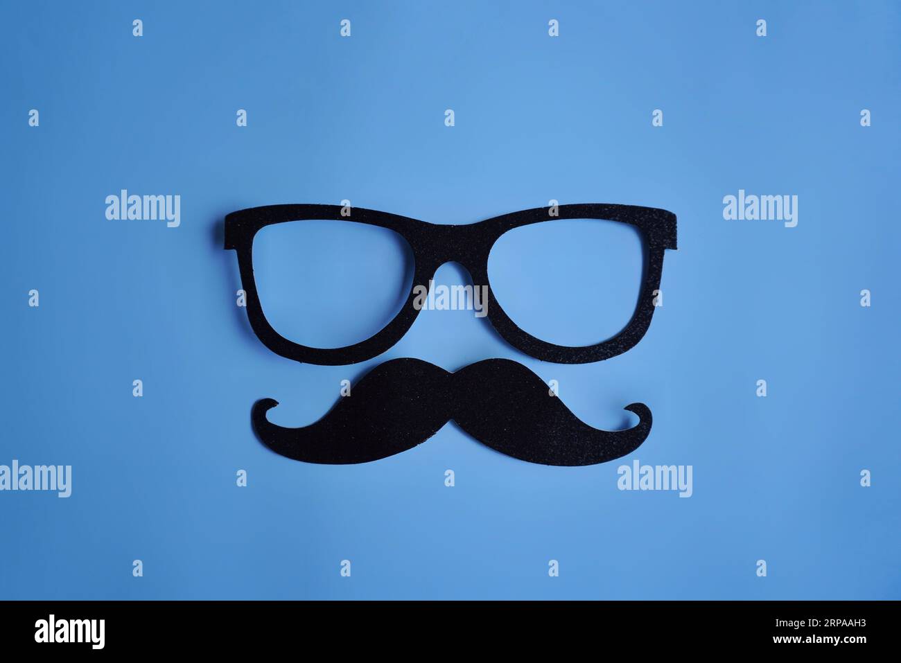 Schnurrbart und Brille auf blauem Hintergrund mit Kopierraum. Movember, Gesundheitskonzept für Männer Stockfoto
