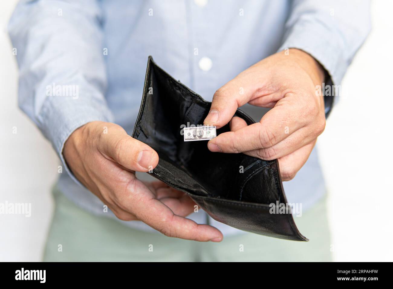 Armutskonzept mit nur einem kleinen 100-Dollar-Schein in einer Ledertasche. Wirtschaftskrisenkonzept. Sinkende Realeinkommen in kleinen Unternehmen. Die Stockfoto