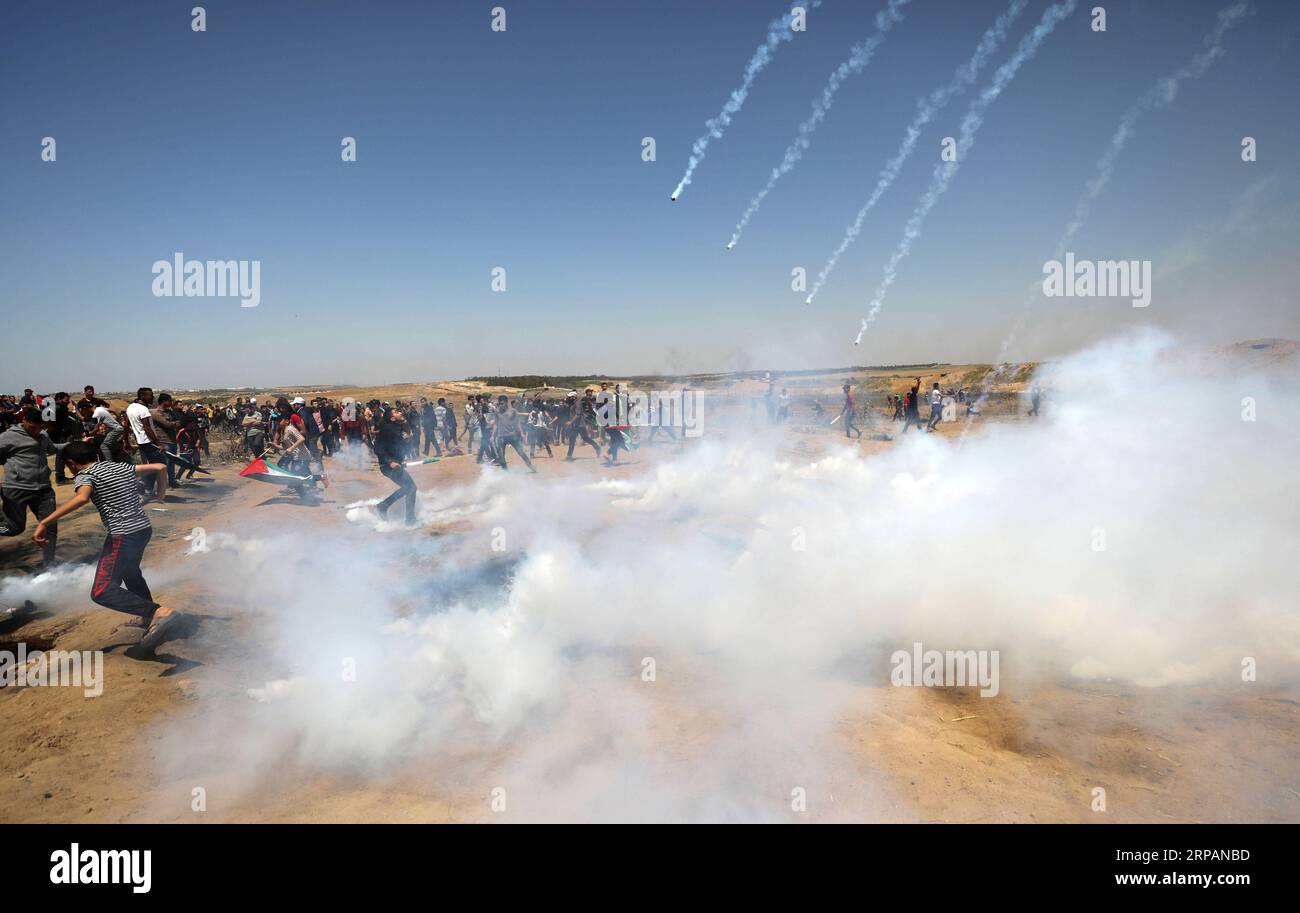 (190515) -- GAZA, 15. Mai 2019 -- Palästinenser laufen in Deckung vor Tränengaskanistern, die von israelischen Truppen während der Auseinandersetzungen an der Grenze zwischen Gaza und Israel, östlich des Flüchtlingslagers al-Bureij im Zentrum von Gaza, am 15. Mai 2019, abgeschossen wurden. Mindestens 47 Palästinenser wurden am Mittwoch bei ihren Zusammenstößen mit israelischen Soldaten verletzt, während sie den 71. Jahrestag des Nakba-Tages oder des Tages der Katastrophe, den Tag nach der Unabhängigkeitserklärung Israels im Jahr 1948, begehen. ) MIDEAST-GAZA-KONFLIKTE YasserxQudih PUBLICATIONxNOTxINxCHN Stockfoto