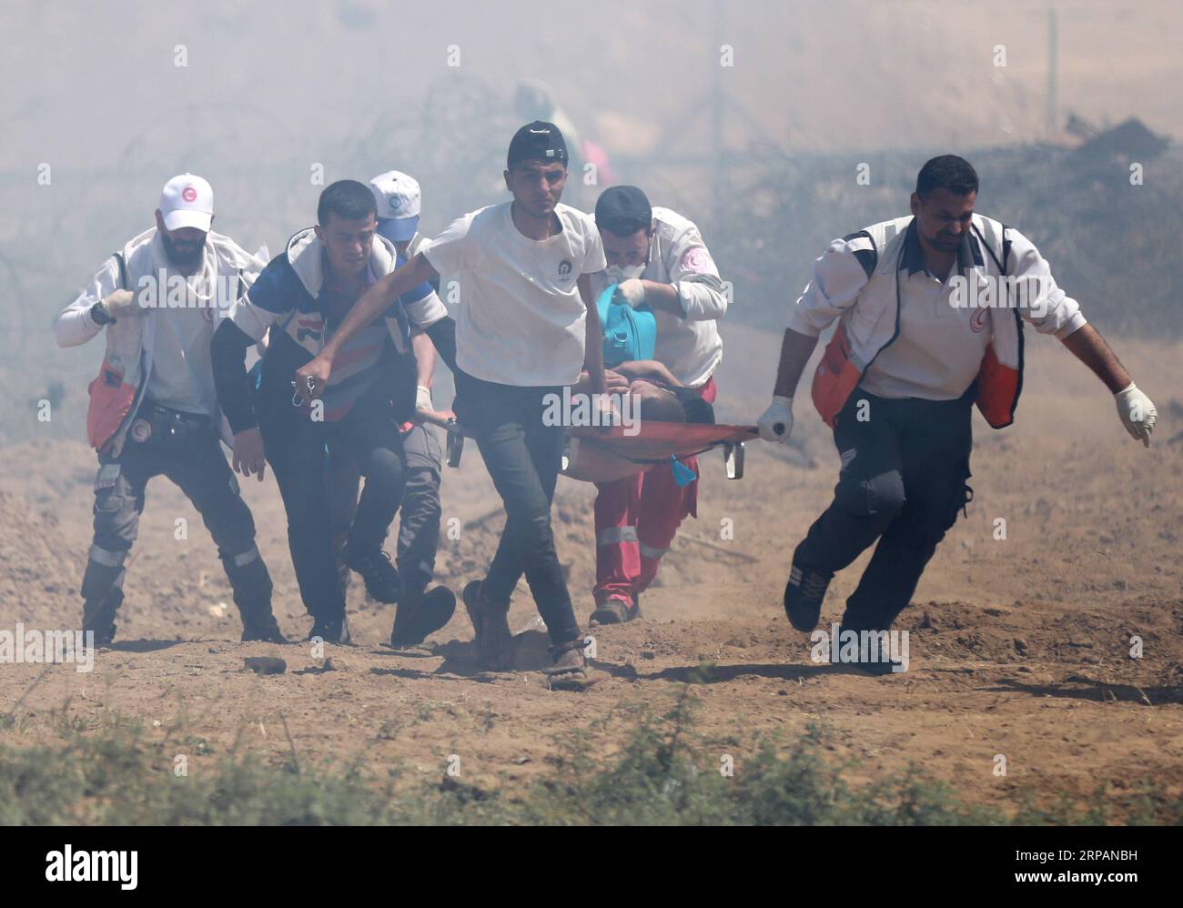 (190515) -- GAZA, 15. Mai 2019 -- palästinensische Sanitäter tragen einen Verwundeten bei Zusammenstößen mit israelischen Truppen an der Grenze zwischen Gaza und Israel, östlich des Flüchtlingslagers al-Bureij im Zentrum von Gaza, 15. Mai 2019. Mindestens 47 Palästinenser wurden am Mittwoch bei ihren Zusammenstößen mit israelischen Soldaten verletzt, während sie den 71. Jahrestag des Nakba-Tages oder des Tages der Katastrophe, den Tag nach der Unabhängigkeitserklärung Israels im Jahr 1948, begehen. ) MIDEAST-GAZA-KONFLIKTE YasserxQudih PUBLICATIONxNOTxINxCHN Stockfoto