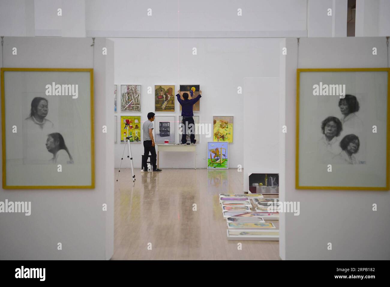 (190524) -- XI AN, 24. Mai 2019 (Xinhua) -- Mitarbeiter hängen die Werke von Absolventen der Xi an Academy of Fine Arts in einem Ausstellungszentrum in Xi an, Provinz Shaanxi im Nordwesten Chinas, 24. Mai 2019. Absolventen von 2019 von der Xi an Academy of Fine Arts waren kürzlich mit ihren Abschlussarbeiten beschäftigt. (Xinhua/Shao Rui) CHINA-SHAANXI-XI AN-GRADUATE-WORK (CN) PUBLICATIONxNOTxINxCHN Stockfoto