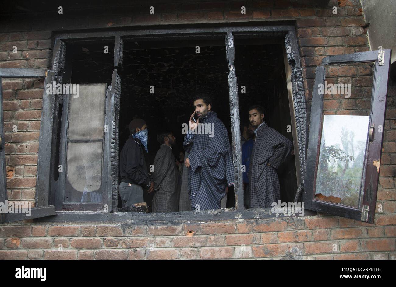 (190524) -- SRINAGAR, 24. Mai 2019 (Xinhua) -- Menschen überprüfen ein Haus, das bei einer Schießerei im Dorf Dadsara von Tral im Bezirk Pulwama, etwa 39 km südlich von Srinagar, der Sommerhauptstadt des von Indien kontrollierten Kaschmirs, am 24. Mai 2019 beschädigt wurde. Ein oberster militanter Kommandeur und Chef der Al-Qaida-Affiliate Ansar Gazwatul Hind -- Zakir Musa wurde Donnerstagabend in einem bewaffneten Kampf mit den Regierungstruppen im von Indien kontrollierten Kaschmir getötet, sagte die Polizei. (Xinhua/Javed dar) KASHMIR-SRINAGAR-GUNFIGHT PUBLICATIONxNOTxINxCHN Stockfoto