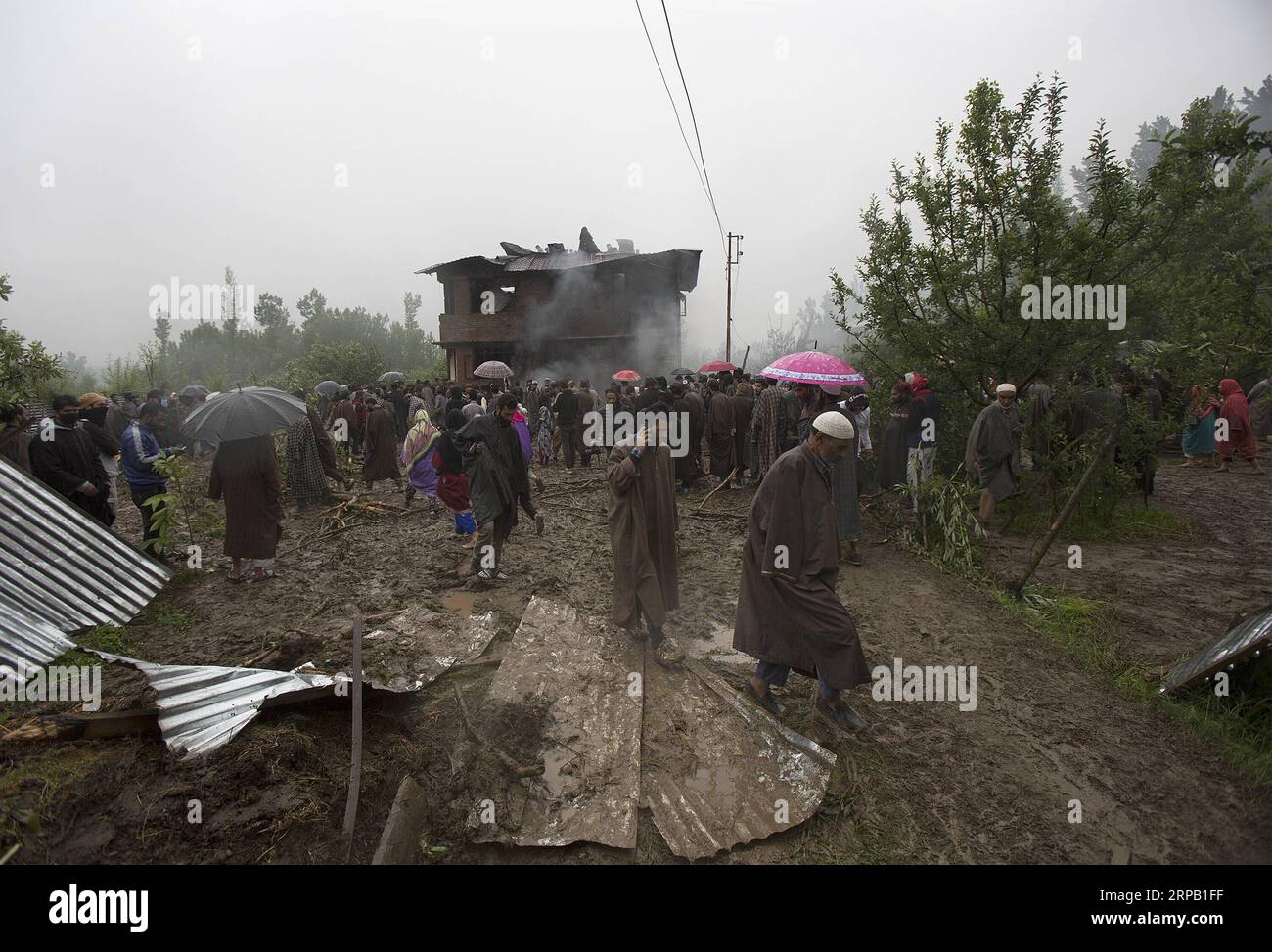 (190524) -- SRINAGAR, 24. Mai 2019 (Xinhua) -- Menschen versammeln sich in der Nähe eines Hauses, das bei einer Schießerei im Dorf Dadsara von Tral im Bezirk Pulwama, etwa 39 km südlich von Srinagar, der Sommerhauptstadt des von Indien kontrollierten Kaschmirs, am 24. Mai 2019 beschädigt wurde. Ein oberster militanter Kommandeur und Chef der Al-Qaida-Affiliate Ansar Gazwatul Hind -- Zakir Musa wurde Donnerstagabend in einem bewaffneten Kampf mit den Regierungstruppen im von Indien kontrollierten Kaschmir getötet, sagte die Polizei. (Xinhua/Javed dar) KASHMIR-SRINAGAR-GUNFIGHT PUBLICATIONxNOTxINxCHN Stockfoto