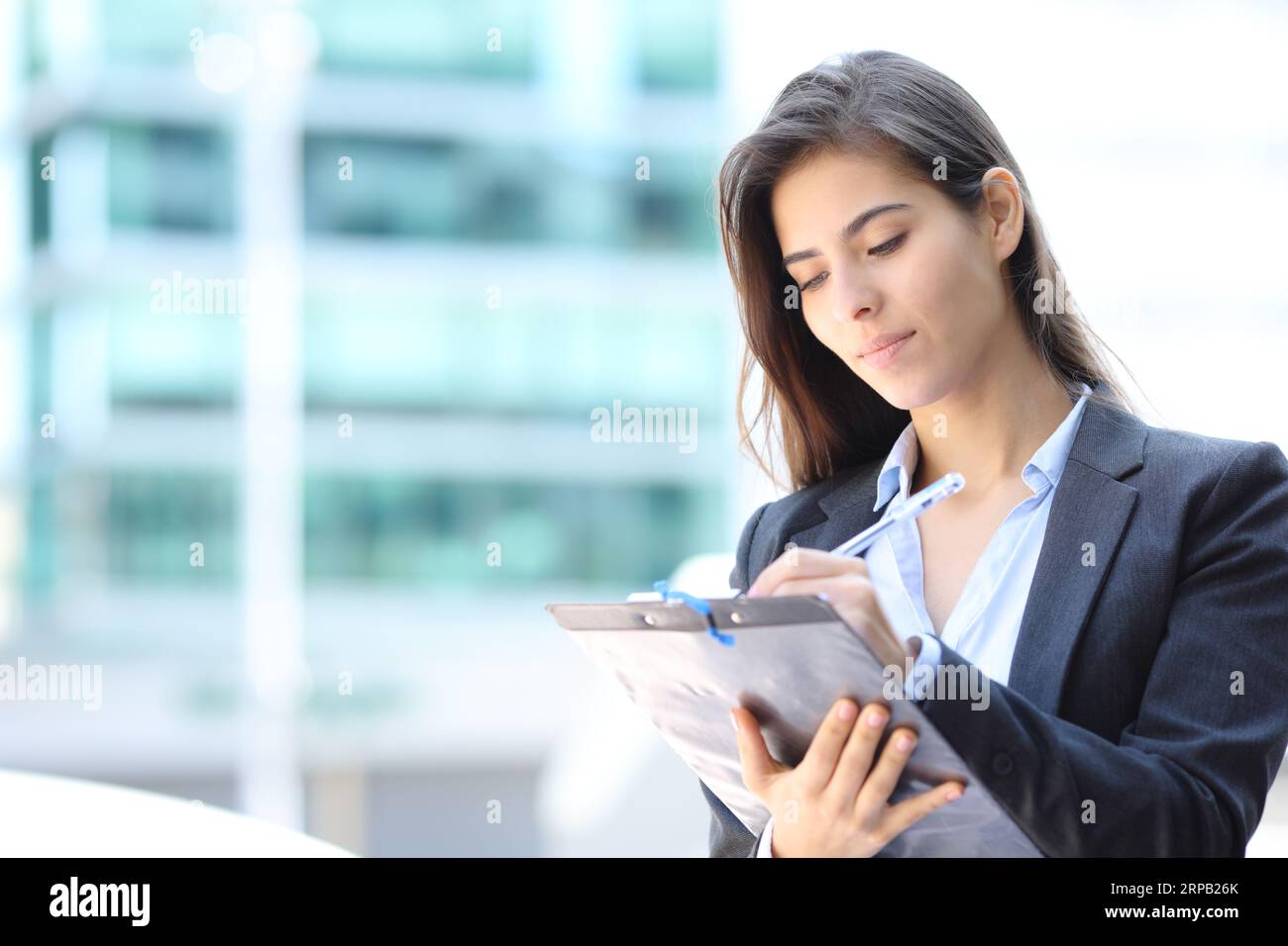 Geschäftsfrau, die das Formular ausfüllt, steht auf der Straße Stockfoto