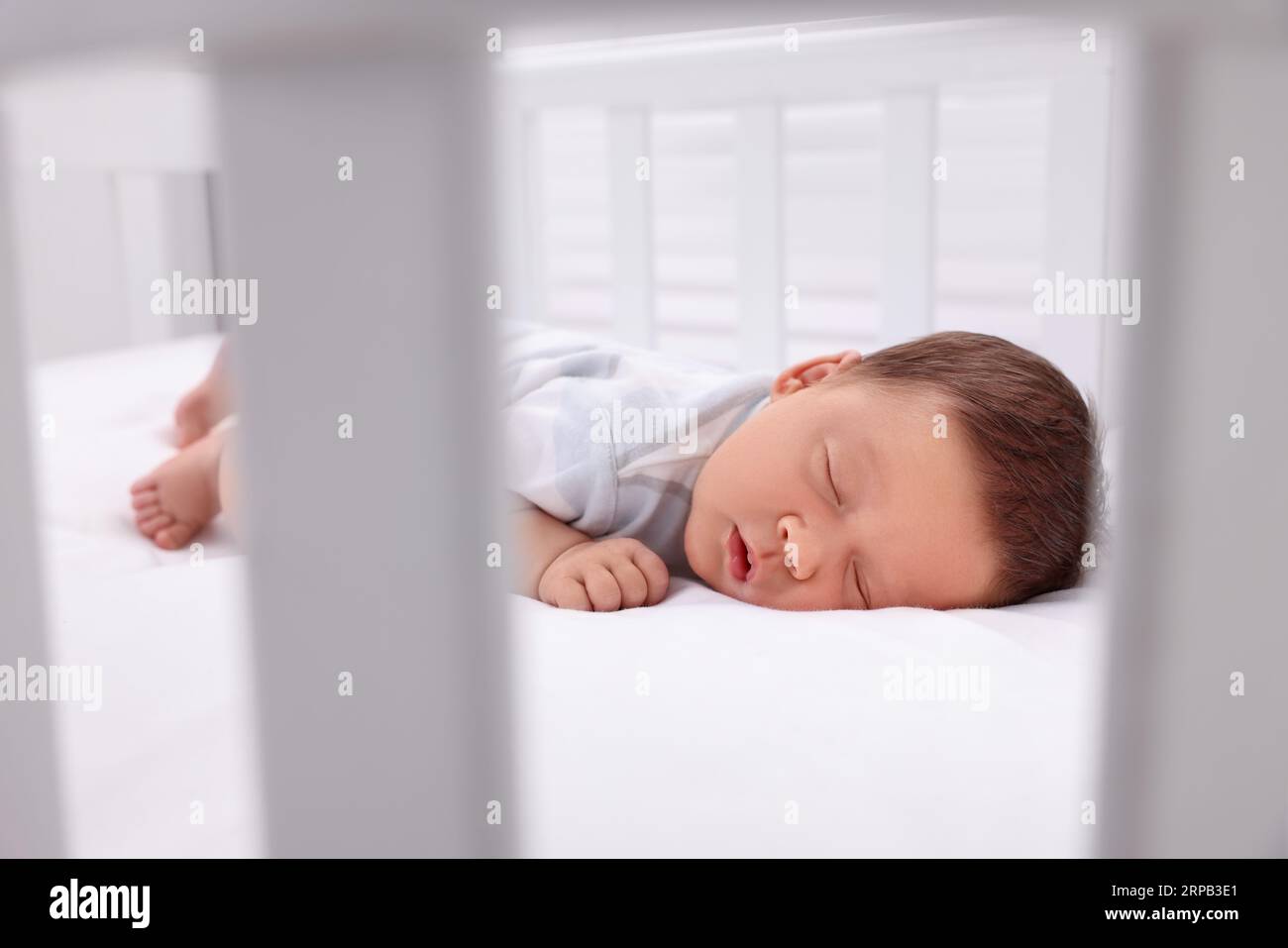 Niedliches Neugeborenes, das im Kinderbett schläft. Schlafenszeit Stockfoto