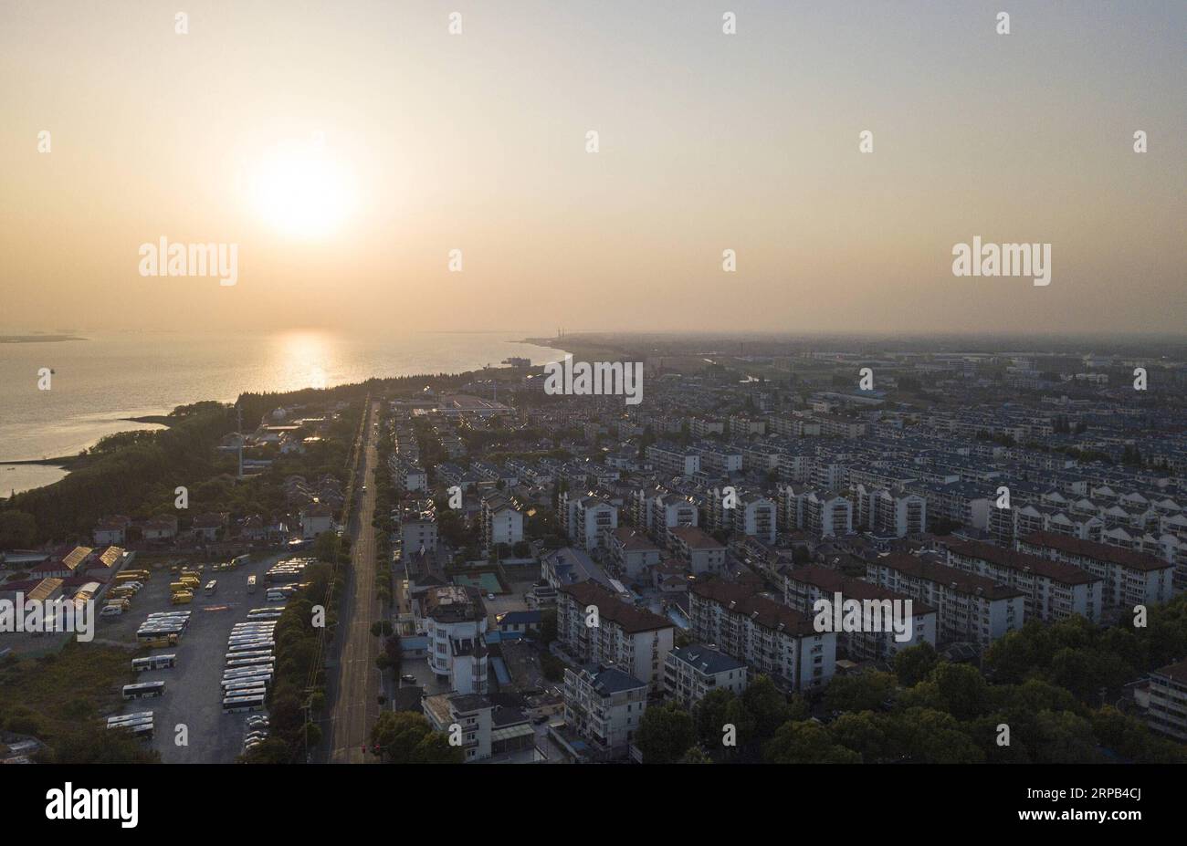 (190527) -- SHANGHAI, 27. Mai 2019 (Xinhua) -- Luftaufnahme, aufgenommen am 25. Mai 2019, zeigt die Sonnenuntergangslandschaft in der Chengqiao Township des Chongming Bezirks, Ost-chinesisches Shanghai. Shanghai liegt in der Mitte der Ostküste Chinas und der Mündung des Yangtze-Flusses und ist Chinas größtes Wirtschaftszentrum sowie das regionale Drehkreuz der Yangtze-Delta-Region. Als Hinterhof dieser wohlhabenden Metropole ist Chongming Island, eines der ländlichen Bezirke Shanghais, auf dem Weg, sein Ziel zu erreichen, eine ökologische Insel von Weltklasse zu entwickeln. Die Feuchtgebiete der Insel sind erhalten, und ihre Traditiona Stockfoto