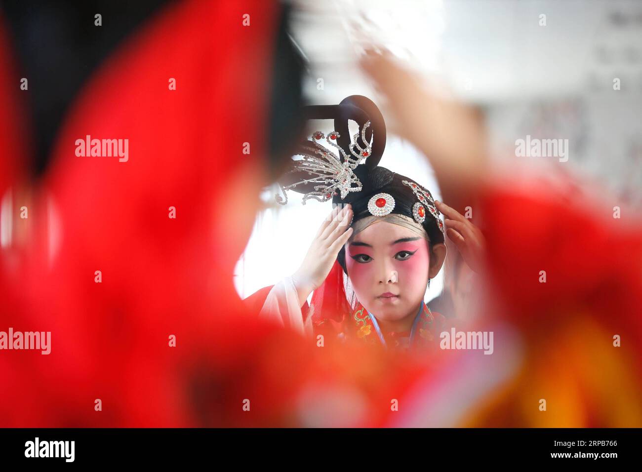 (190530) -- QINGDAO, 30. Mai 2019 (Xinhua) -- Ein Schüler arrangiert Kopfaccessoires vor einem Auftritt in der Tongji Experimental School in Qingdao, ostchinesische Provinz Shandong, 30. Mai 2019. Die Tongji Experimental School integriert die Peking Opera in ihre Kurse ab September 2018, um die traditionelle chinesische Kultur zu erben. (Xinhua/Liang Xiaopeng) CHINA-SHANDONG-QINGDAO-PEKING OPERA-INHERITING (CN) PUBLICATIONxNOTxINxCHN Stockfoto