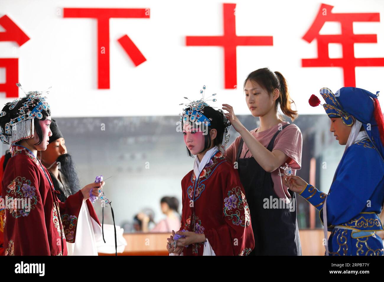 (190530) -- QINGDAO, 30. Mai 2019 (Xinhua) -- Ein Lehrer organisiert das Kopfzubehör für einen Schüler der Tongji Experimental School in Qingdao, Ostchinesische Provinz Shandong, 30. Mai 2019. Die Tongji Experimental School integriert die Peking Opera in ihre Kurse ab September 2018, um die traditionelle chinesische Kultur zu erben. (Xinhua/Liang Xiaopeng) CHINA-SHANDONG-QINGDAO-PEKING OPERA-INHERITING (CN) PUBLICATIONxNOTxINxCHN Stockfoto