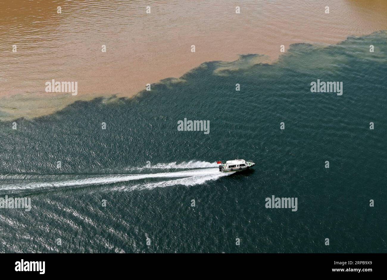 (190602) -- YONGJING, 2. Juni 2019 (Xinhua) -- Foto vom 2. Juni 2019 zeigt eine Yacht, die im Liujiaxia Reservoir im Yongjing County, nordwestlich der chinesischen Provinz Gansu segelt. Ein scharfer Farbkontrast zeigt sich deutlich, wenn sich zwei Flüsse, der seilfreie Yellow River und der dazugehörige Taohe River, der mit viel Schlamm und Sand fließt, im Liujiaxia Reservoir treffen, das weithin für sein klares Wasser bekannt ist. (Xinhua/Ma Ning) CHINA-GANSU-YONGJING-LIUJIAXIA STAUSEE-LANDSCHAFT (CN) PUBLICATIONxNOTxINxCHN Stockfoto