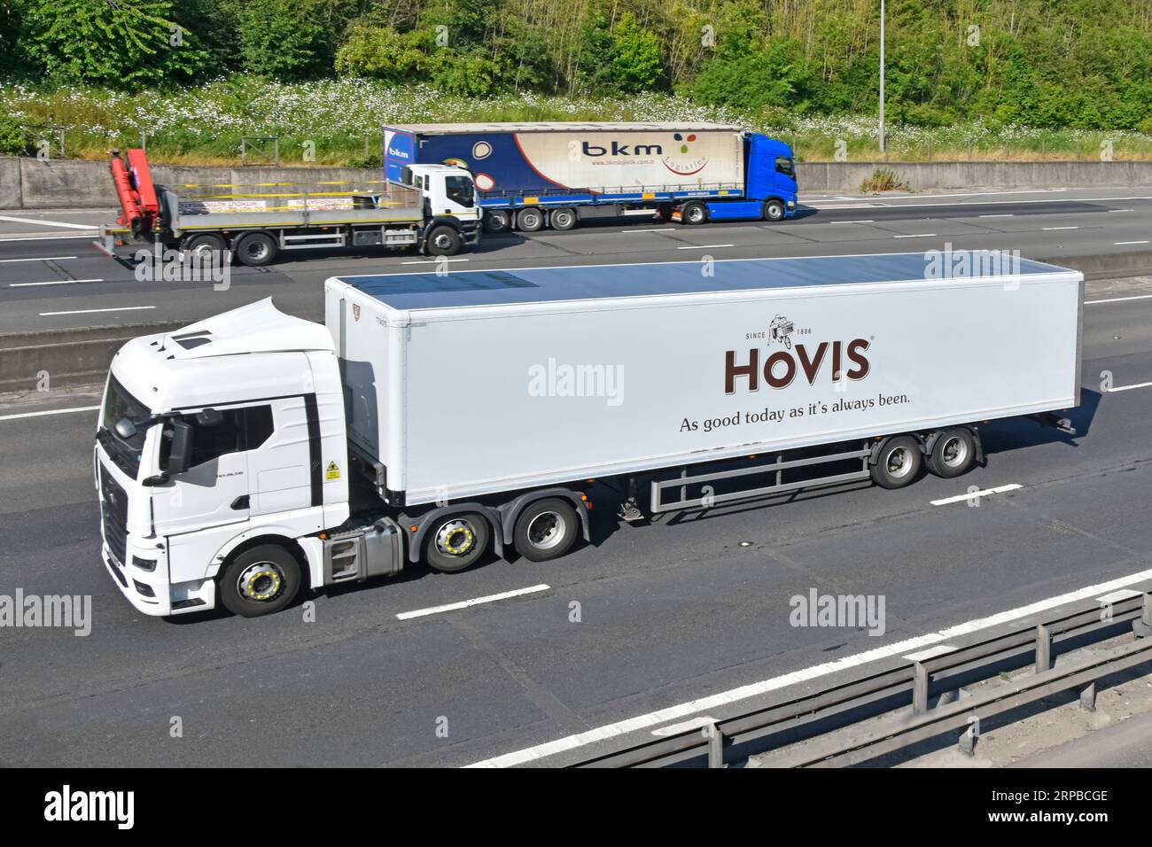 Seitenansicht von vorn, lkw-Lastwagen mit Lastwagen und Hovis Ltd. Mit Knickgelenkauflieger für Mehl- und Brothersteller, die entlang der Autobahn M25 in Großbritannien fahren Stockfoto