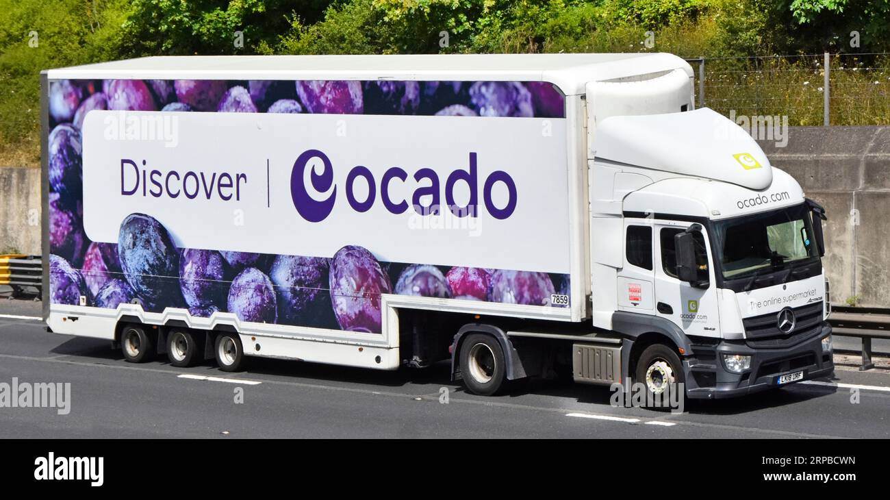 Weißer lkw-Lastkraftwagen, Antriebseinheit mit aerodynamischem Abweiser über dem Fahrerhaus, Ocado-Banner über knickgelenktem Auflieger auf der Autobahn M25 UK Stockfoto