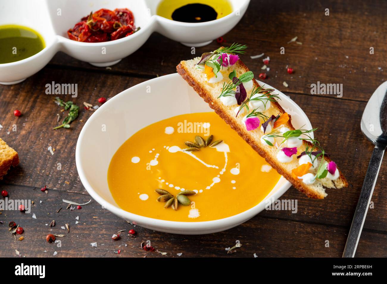 Italienische Kürbissuppe Zuppa di giornata auf weißem Porzellanteller auf Holztisch Stockfoto