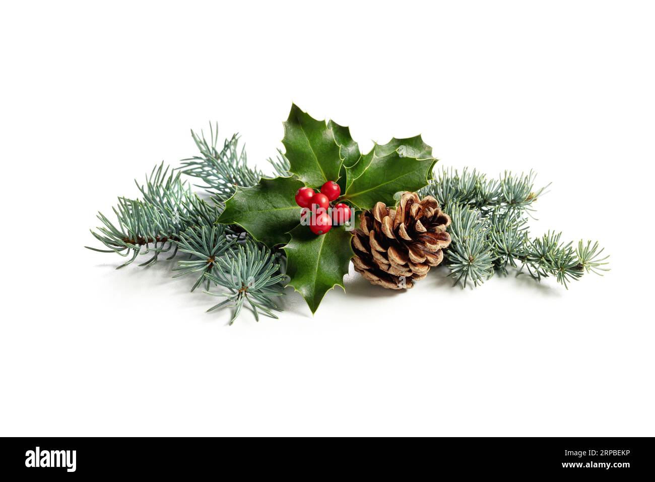 Weihnachtsdekoration aus holly Beere und Kiefernkegel. Traditionelle festliche Dekoration auf weißem Hintergrund. Stockfoto