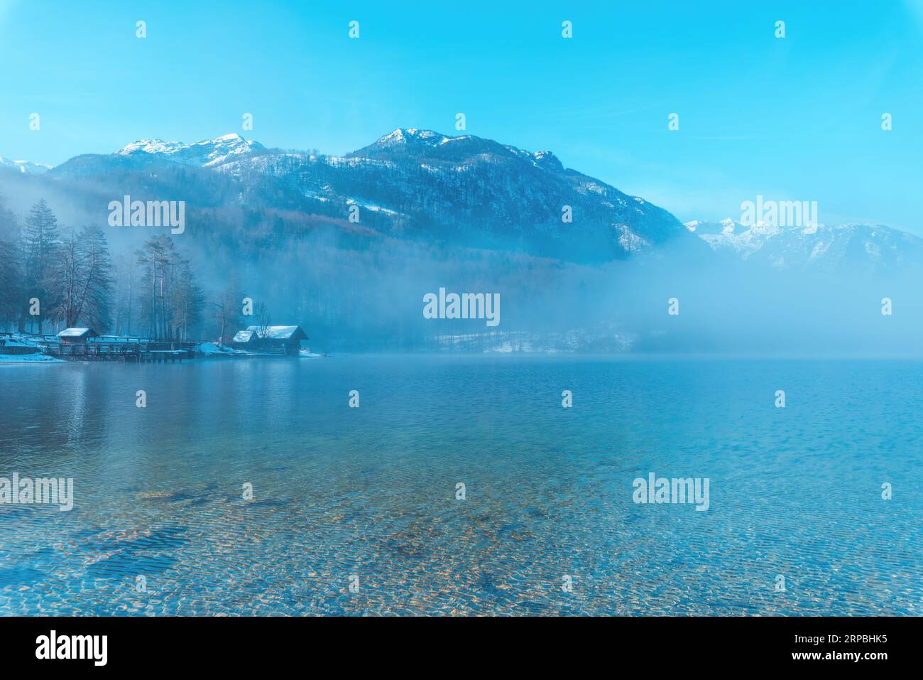 Die Landschaft des Bohinjsees am Wintermorgen, Nebel über sauberem Gletscherwasser im slowenischen Nationalpark Triglav und berühmtem Reiseziel Stockfoto