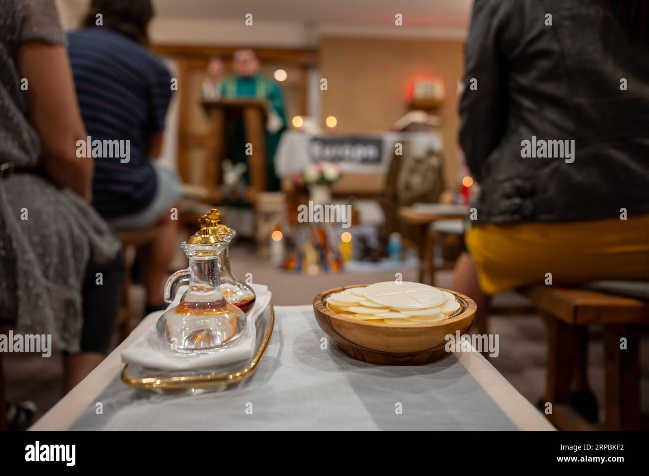 Cruets mit dem Wein und dem Wasser und ein Paten mit dem Brot, das vorbereitet wurde, um während der heiligen Messe zum Altar getragen zu werden. Stockfoto