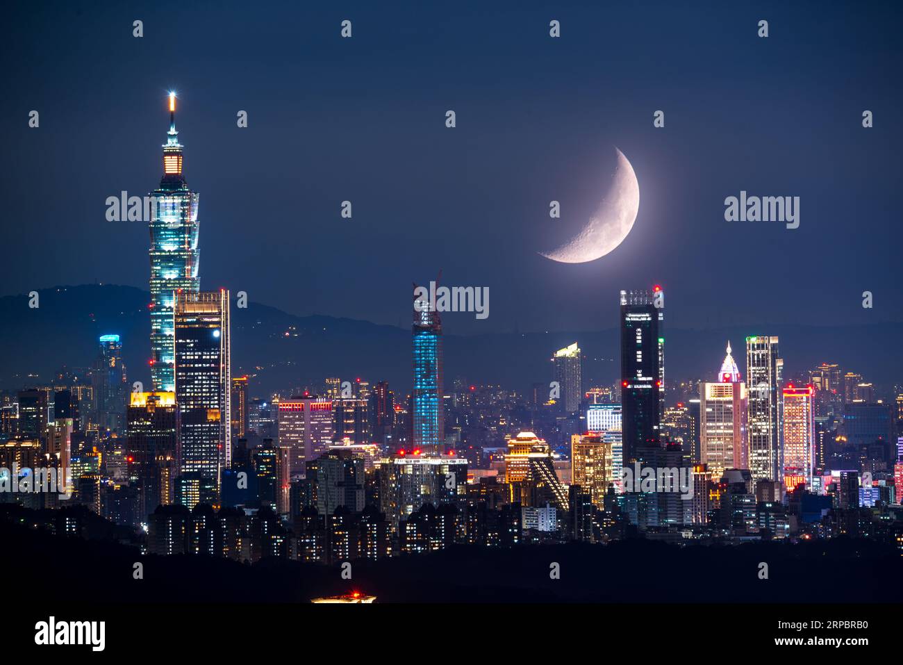 Moonlit Urban Nights: The Beauty of City Lights and a Shining Moon. Genießen Sie den nächtlichen Blick auf Taipei City vom Neihu Bishanyan Tempel. Stockfoto