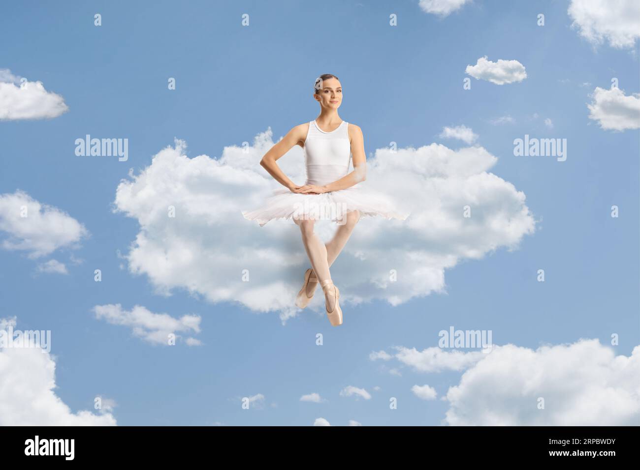 Wunderschöne Ballerina, die auf einer Wolke am Himmel sitzt Stockfoto