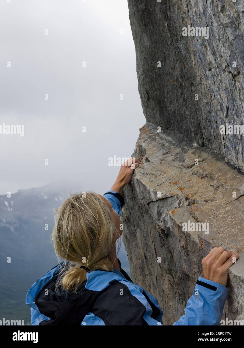 Porträt einer Frau, die steile Felswände besteigt Stockfoto