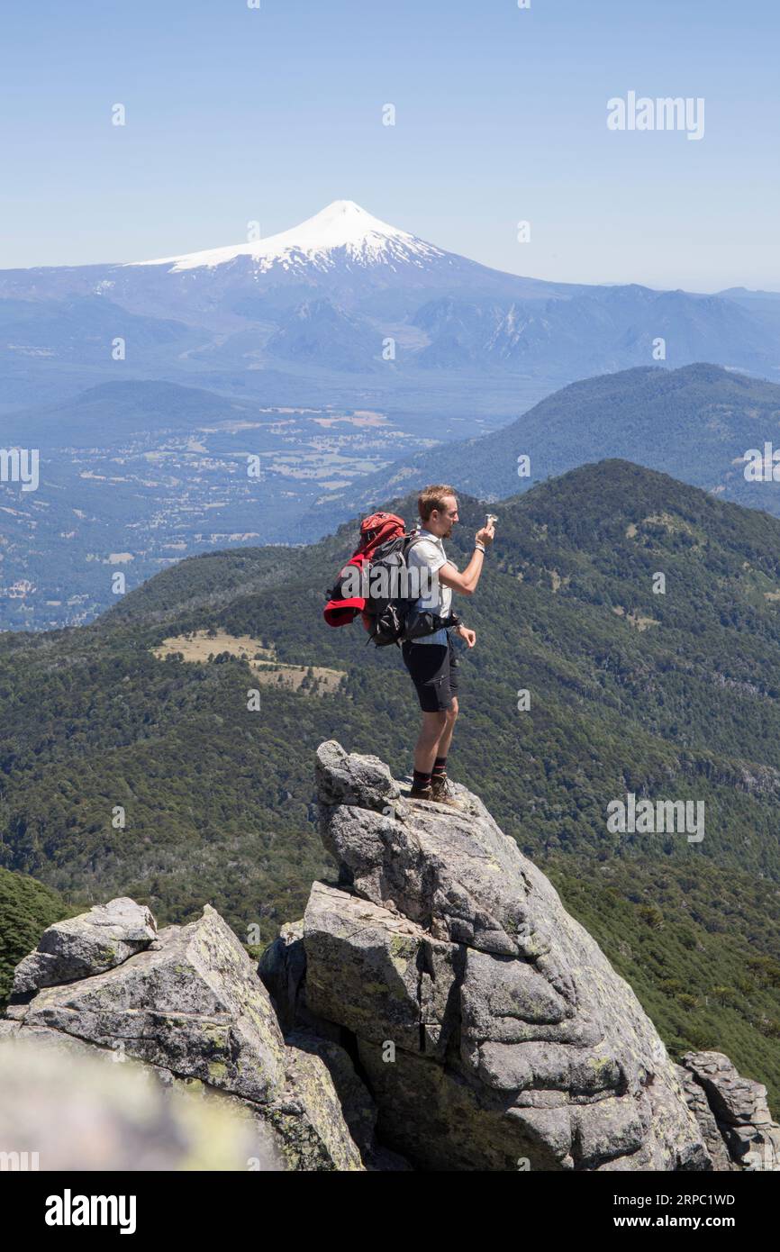 Wanderer macht Fotos auf dem Gipfel vor dem Vulkan Stockfoto