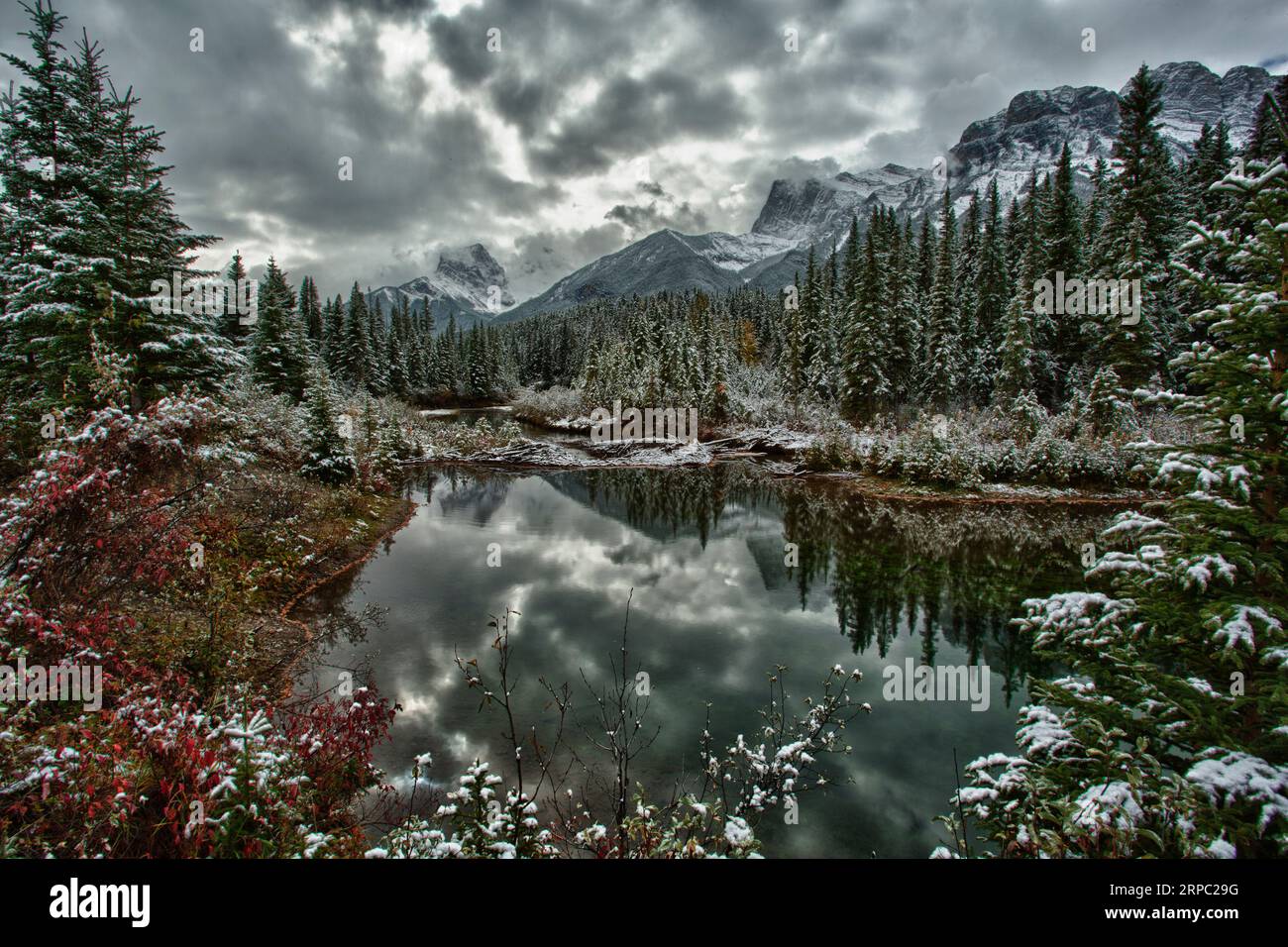 Berge und Wolken spiegeln sich im See, Winter Stockfoto
