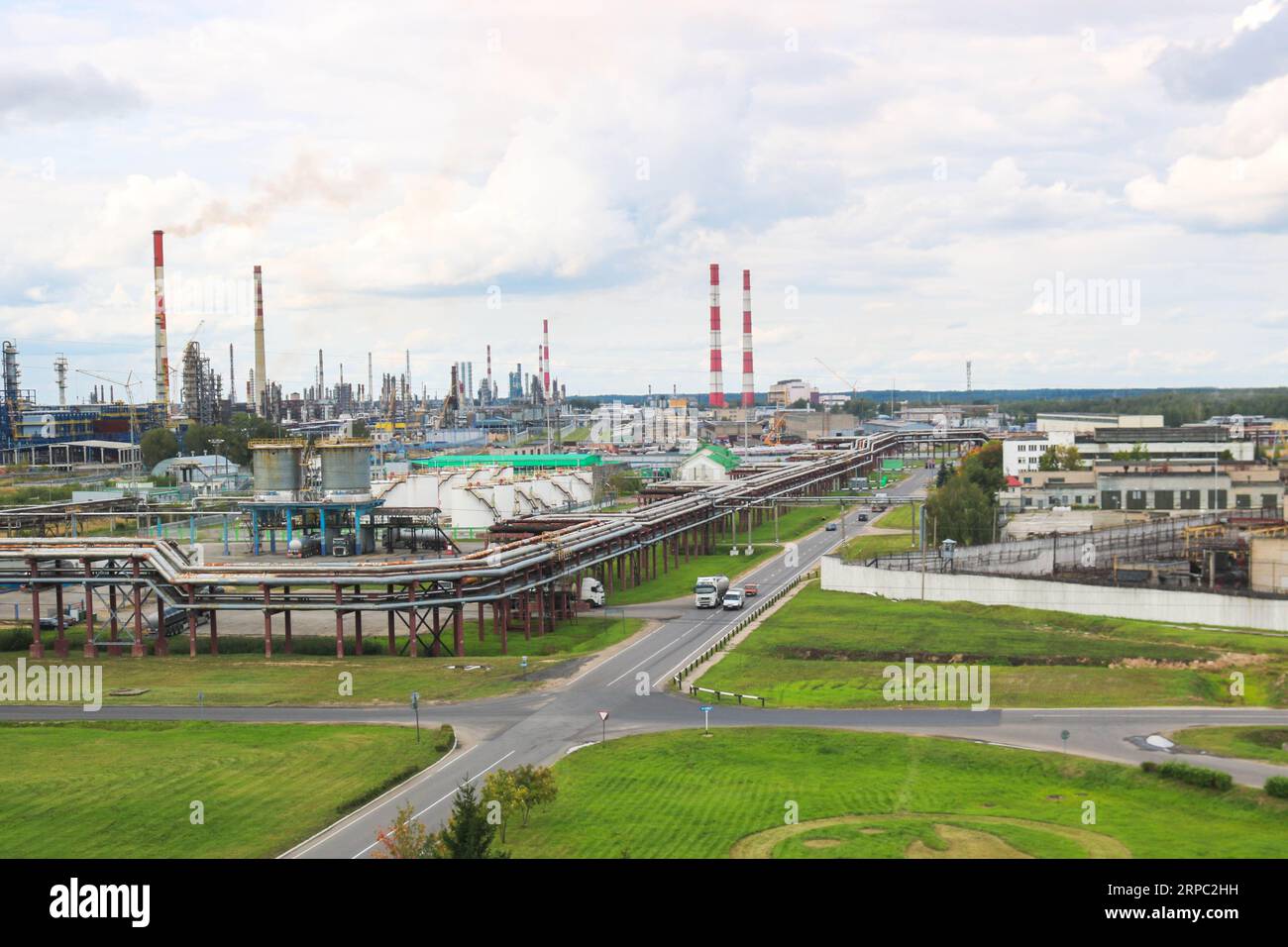 Industrielandschaft. Panoramablick auf die technologischen Rohre. Werkseinstellungen. Aus den chemischen rot-weißen Rohren kommt Rauch. Produktionsgebäude Stockfoto