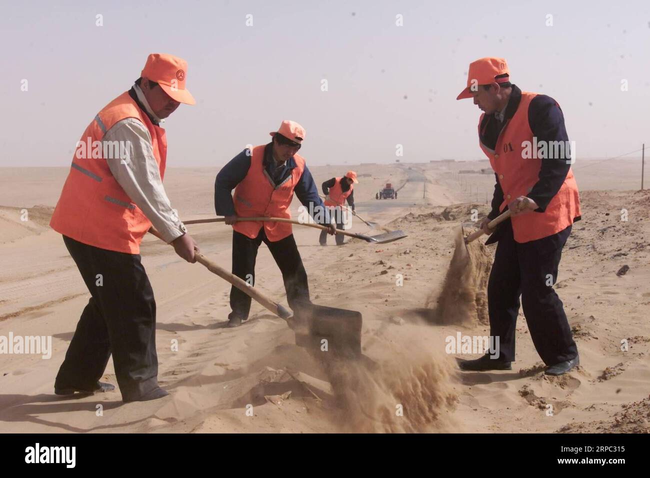 (190622) -- YINCHUAN, 22. Juni 2019 (Xinhua) -- das am April 2002 aufgenommene Aktenfoto zeigt Arbeiter, die eine mit Sand bedeckte Straße in der Gemeinde Jianerzhuang im Yanchi County, der nordwestchinesischen Autonomen Region Ningxia Hui, abräumen. Das am südlichen Rand der Maowusu-Wüste gelegene Yanchi County war einst von Armut betroffen und litt unter Wüstenbildung. Aber nach jahrelangen Bemühungen wurde die Umwelt dort wiederhergestellt, und auch die Grafschaft hat die Armut abgeschwächt. (Xinhua/Liu Quanlong) CHINA-NINGXIA-YANCHI-POVERTY ELIMINATION (CN) PUBLICATIONxNOTxINxCHN Stockfoto