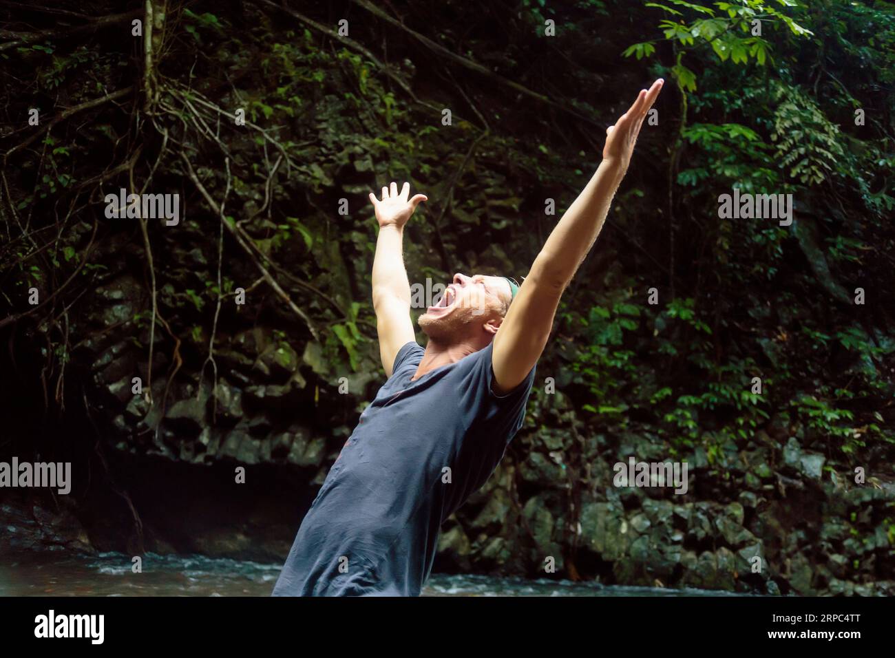 Mann, der mit erhobenen Armen schreit, Kintamani, Bali, Indonesien Stockfoto