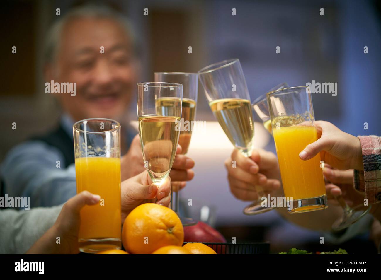 Ein älterer asiatischer Mann, der während einer Familienfeier anspricht, glücklich und lächelnd Stockfoto
