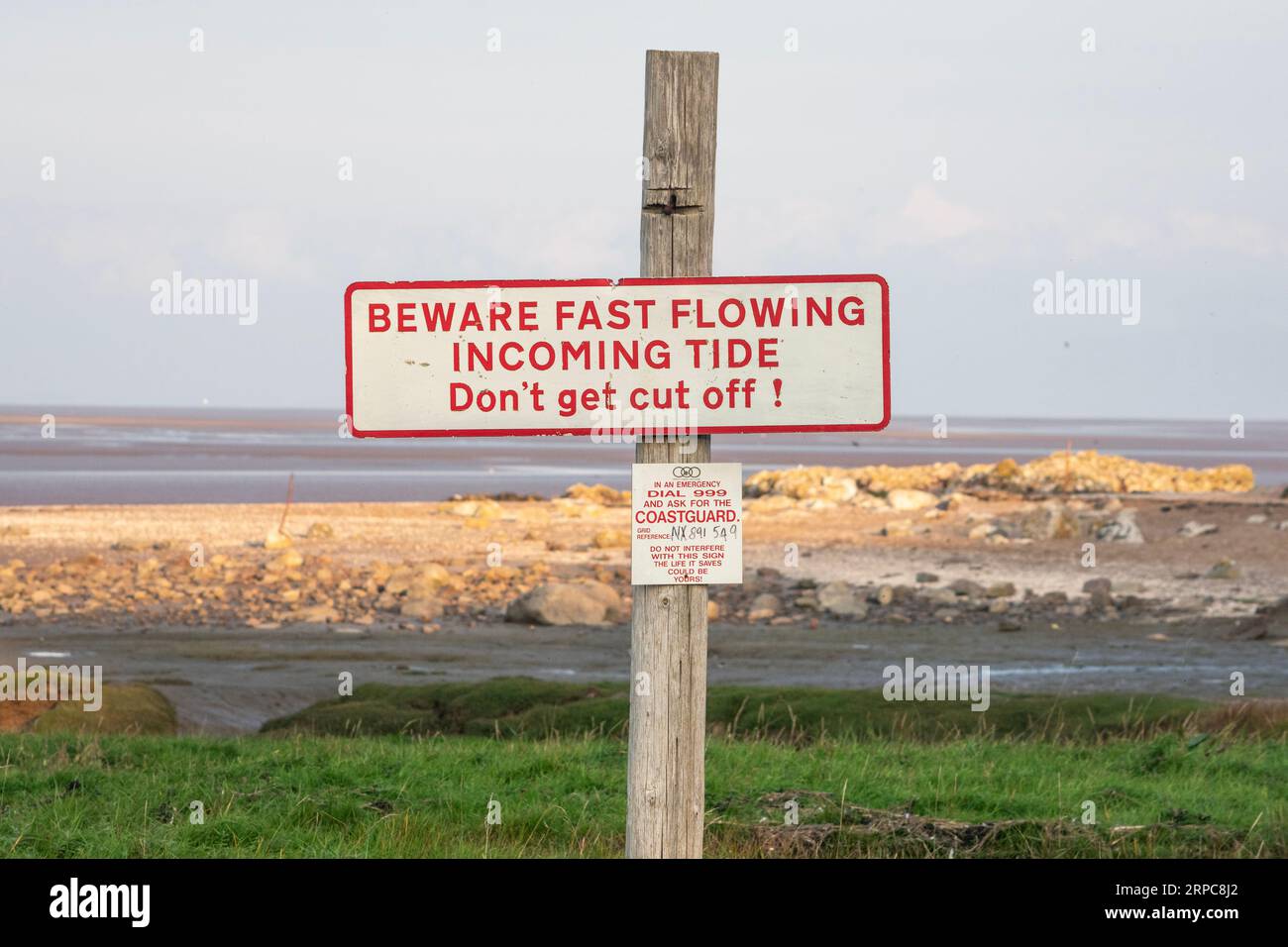 Warnschild am Strand vor eingehender Flut Stockfoto