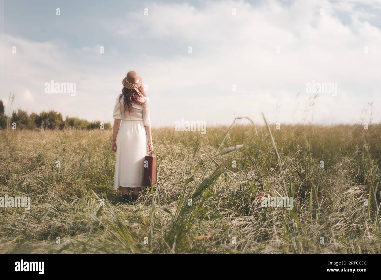 Reisende Frau mit Koffer zu Fuß in einer surrealen Landschaft, Konzept der Mobilität in Raum und Zeit Stockfoto