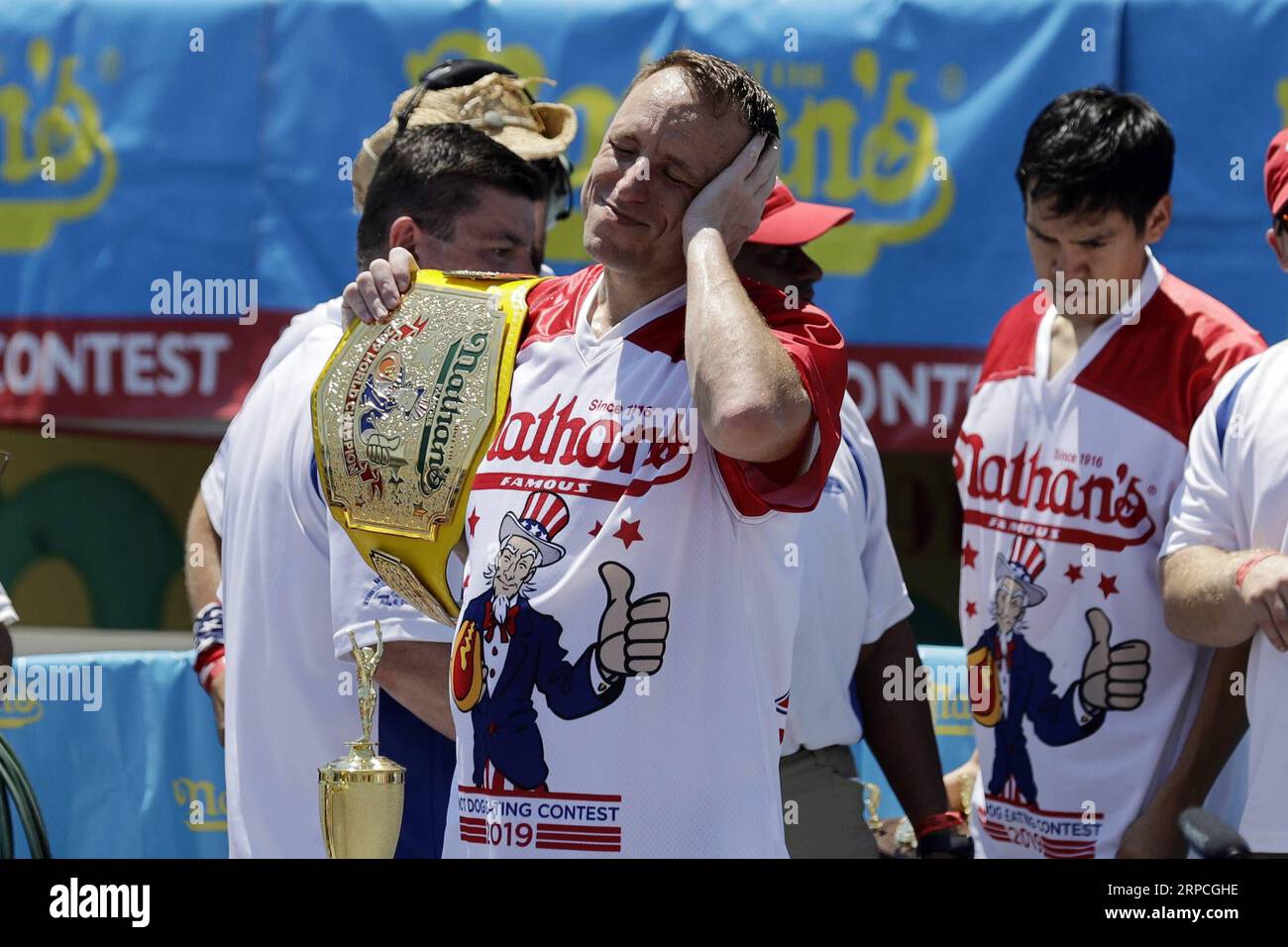 (190704) -- NEW YORK, 4. Juli 2019 -- Joey Chestnut (Front) feiert, nachdem er den Männerwettbewerb beim jährlichen Nathan s Hot Dog Eating Contest auf Coney Island in New York, USA, am 4. Juli 2019 gewonnen hat. Joey Chestnut verteidigte seinen Meistertitel am Donnerstag mit 71 Hot Dogs in 10 Minuten beim Nathan's Hot Dog Eating Contest in New York. Miki Sudo verteidigte den Titel der Frauen, indem er 31 Hot Dogs in 10 Minuten aß. U.S.-NEW YORK-HOT DOG EATING CONTEST LIXMUZI PUBLICATIONXNOTXINXCHN Stockfoto