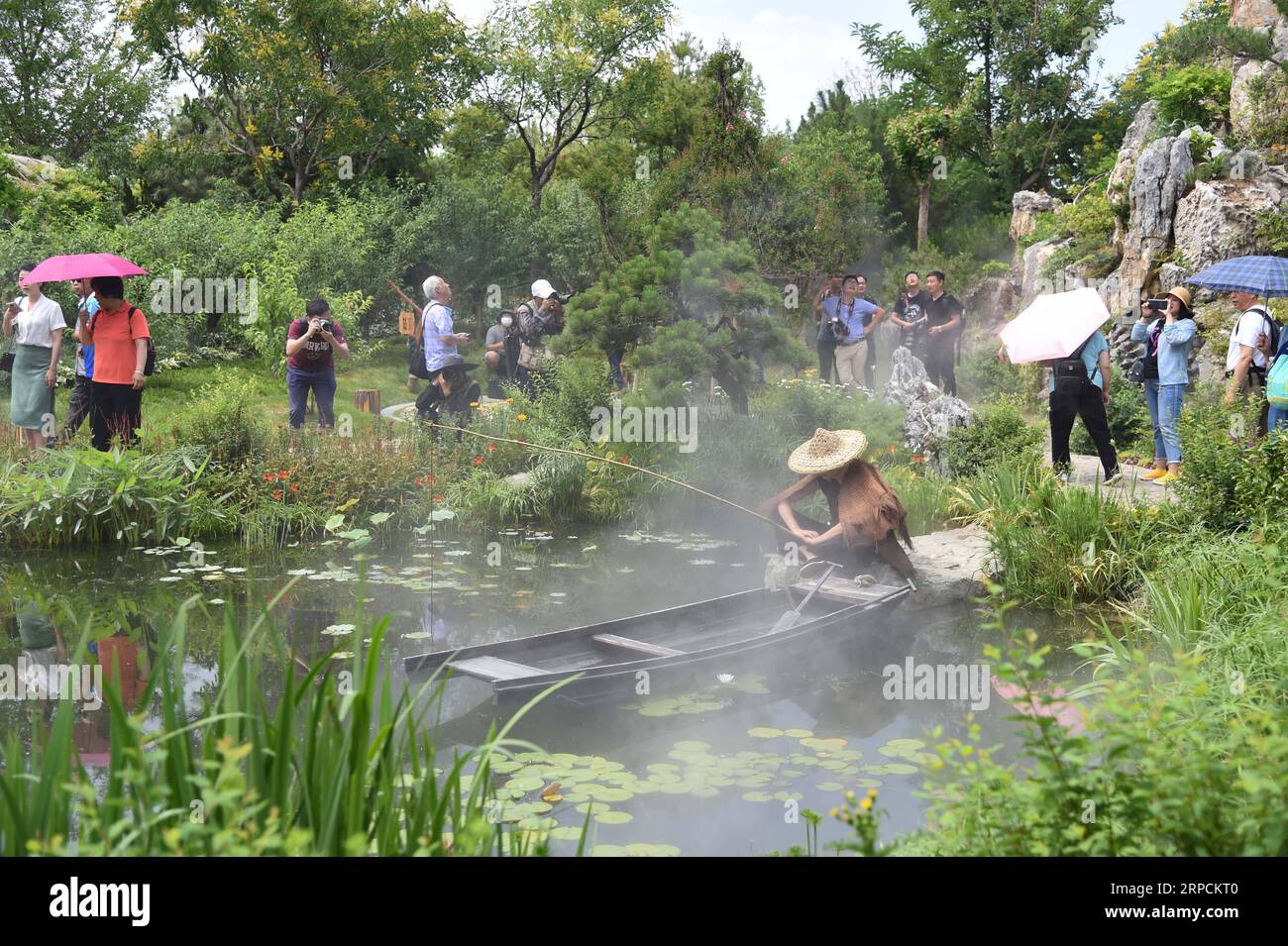 (190708) -- PEKING, 8. Juli 2019 -- Touristen besuchen den Hunan-Garten auf der Pekinger Internationalen Gartenausstellung in Peking, Hauptstadt von China, 7. Juli 2019. Die Provinz Hunan liegt in Zentralchina und ist für ihre abwechslungsreiche Topographie bekannt. Er grenzt im Norden an den Dongting Lake, und die Ost-, Süd- und Westseite der Provinz sind von Bergen umgeben, mit den Wuling- und Xuefeng-Bergen im Westen, dem Nanling-Berg im Süden, den Luoxiao- und den Mufu-Bergen im Osten. Die Flüsse Xiangjiang, Zijiang, Yuanjiang und Lishui treffen auf dem Yangtze River am Dongting Lake im N zusammen Stockfoto