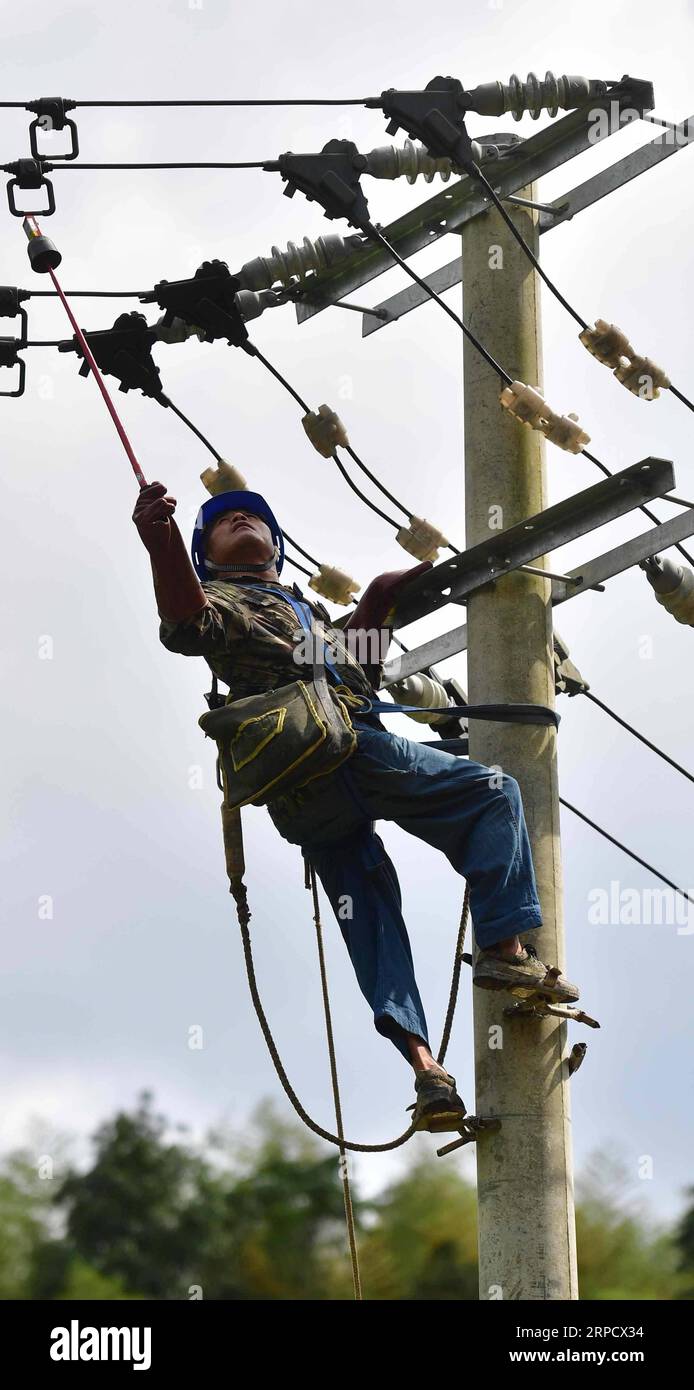 (190714) -- RONGAN, 14. Juli 2019 -- ein Elektriker des lokalen Netzes repariert Stromleitungen im Dorf Daqin der Gemeinde Yayao, Kreis Rongan, südchinesische autonome Region Guangxi Zhuang, 14. Juli 2019. Seit Rong an kürzlich von schweren Regenfällen getroffen wurde, wurden eine Reihe von Rekonstruktions- und Rettungsarbeiten durchgeführt. ) CHINA-GUANGXI-RONGAN-FLOODS-RECONSTRUCTION (CN) HUANGXXIAOBANG PUBLICATIONXNOTXINXCHN Stockfoto