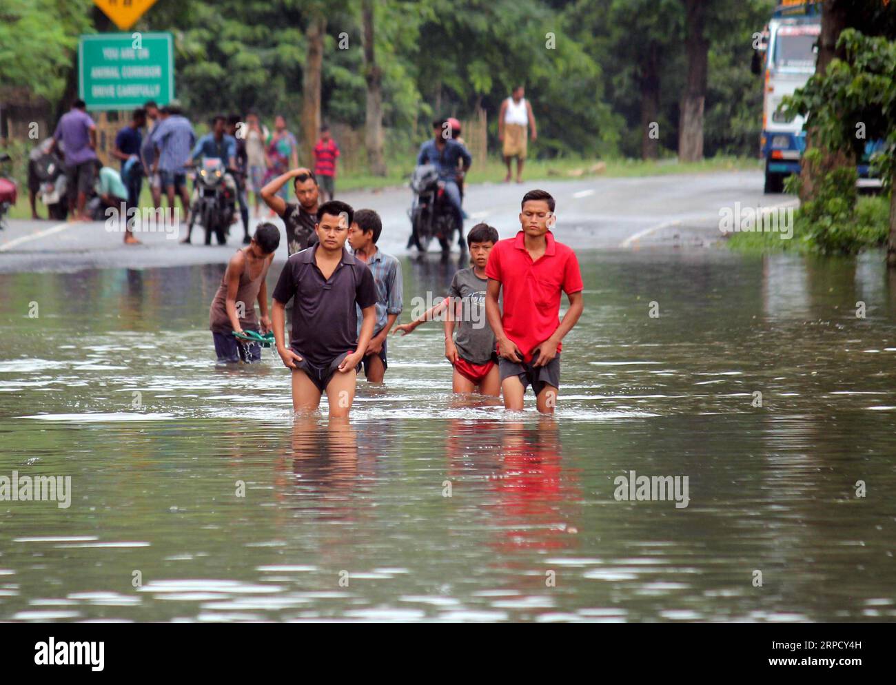 (190716) -- ASSAM, 16. Juli 2019 -- Dorfbewohner laufen auf einer überfluteten Straße in der Nähe des Kaziranga-Heiligtums in Assam, Indien, 15. Juli 2019. Mehr als 35 Menschen sind gestorben, und mehr als 2,6 Millionen andere sind von Überschwemmungen betroffen, die Indiens östlichen Bundesstaat Bihar und den nordöstlichen Bundesstaat Assam heimsuchen, sagten Medienberichte am Montag. (STR/Xinhua) INDIA-WEATHER-FLOOD ZhangxNaijie PUBLICATIONxNOTxINxCHN Stockfoto