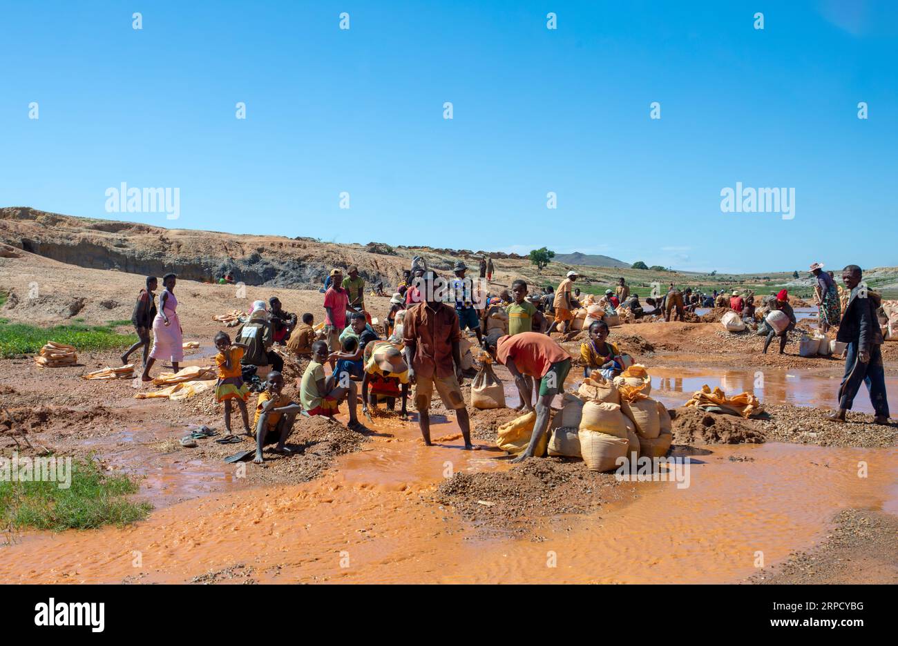 Ihosy, Ilakaka, Madagaskar - 20. November 2022: Die Einheimischen suchen nach Edelsteinen und Pfannen nach Gold in einem Fluss. Die Stadt ist ein wichtiges Zentrum für Saphirprodukte Stockfoto