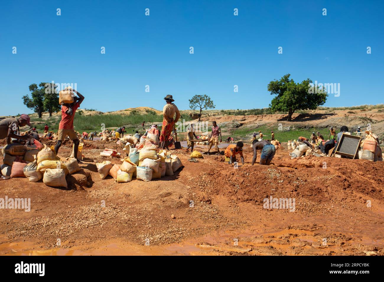 Ihosy, Ilakaka, Madagaskar - 20. November 2022: Die Einheimischen suchen nach Edelsteinen und Pfannen nach Gold in einem Fluss. Die Stadt ist ein wichtiges Zentrum für Saphirprodukte Stockfoto