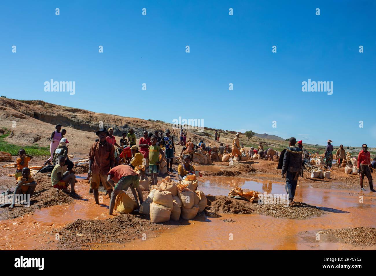 Ihosy, Ilakaka, Madagaskar - 20. November 2022: Die Einheimischen suchen nach Edelsteinen und Pfannen nach Gold in einem Fluss. Die Stadt ist ein wichtiges Zentrum für Saphirprodukte Stockfoto