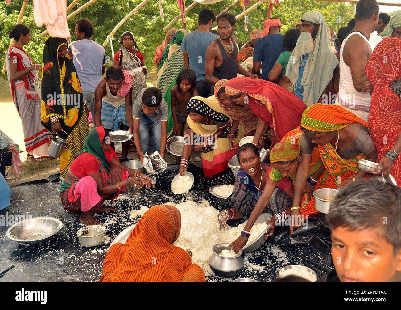 (190718) -- MUZAFFARPUR, 18. Juli 2019 (Xinhua) -- Dorfbewohner verteilen gekochten Reis in einem provisorischen Unterschlupf nach der jüngsten Überschwemmung im Bezirk Muzaffarpur, Bihar, Indien, 17. Juli 2019. Viele Bewohner wurden durch die jüngste Überschwemmung, die durch den unaufhörlichen Regen im indischen Bundesstaat Bihar verursacht wurde, obdachlos gelassen. (STR/Xinhua) INDIA-BIHAR-MUZAFFARPUR-FLOOD-AFTERMATH PUBLICATIONxNOTxINxCHN Stockfoto